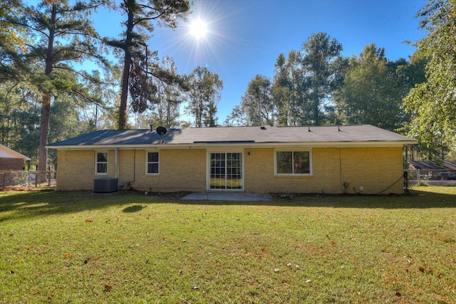 rear view of property with a patio area, a yard, and central AC