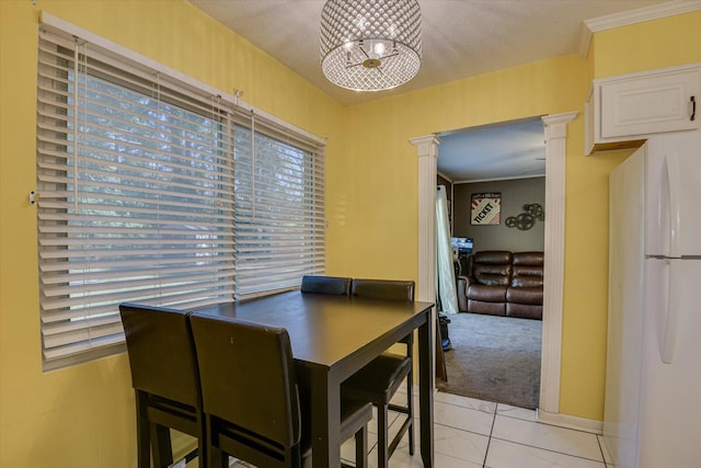 tiled dining room featuring crown molding, a textured ceiling, and decorative columns