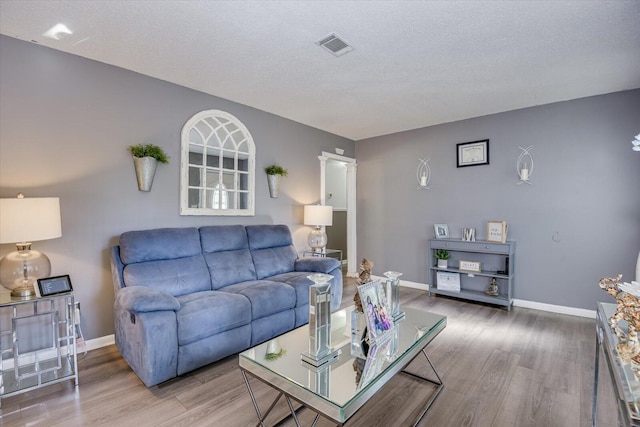 living room with hardwood / wood-style flooring and a textured ceiling