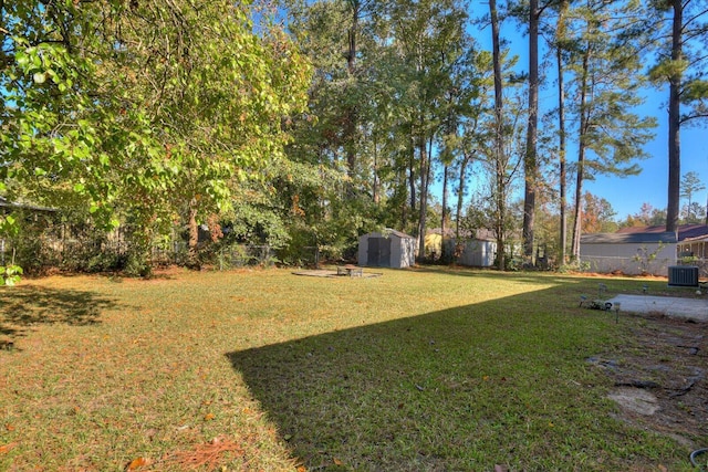 view of yard featuring a storage shed and central AC