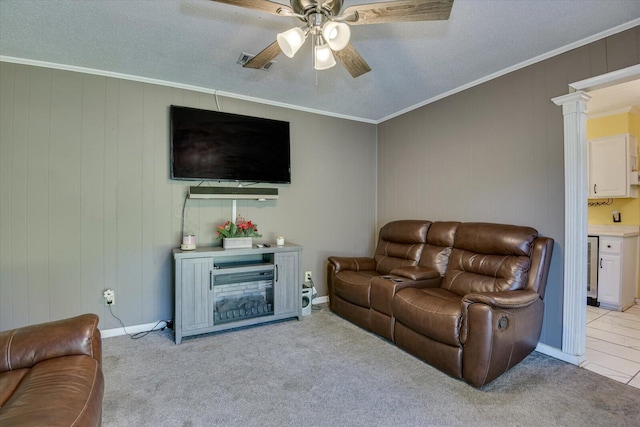 living room featuring ornate columns, ornamental molding, a textured ceiling, light colored carpet, and ceiling fan