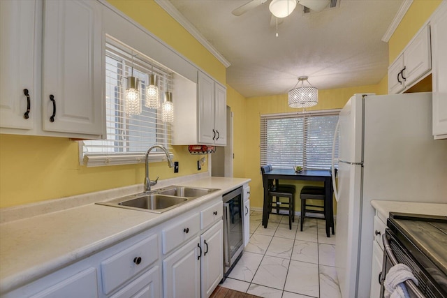 kitchen with ceiling fan, white cabinetry, hanging light fixtures, and sink