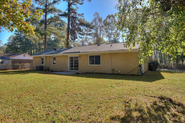 rear view of property with a lawn and cooling unit