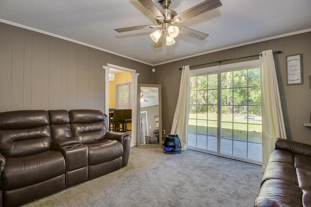 living room with crown molding, wooden walls, carpet, and a textured ceiling