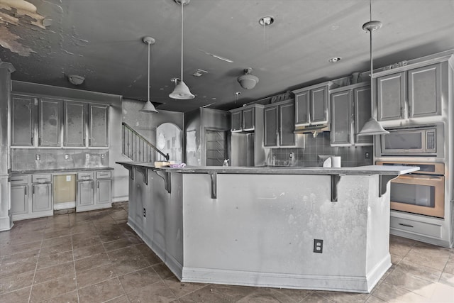 220 Dripping Rock Pass, Grovetown, GA 30813 - kitchen with appliances with stainless steel finishes, backsplash, a kitchen bar, and decorative light fixtures