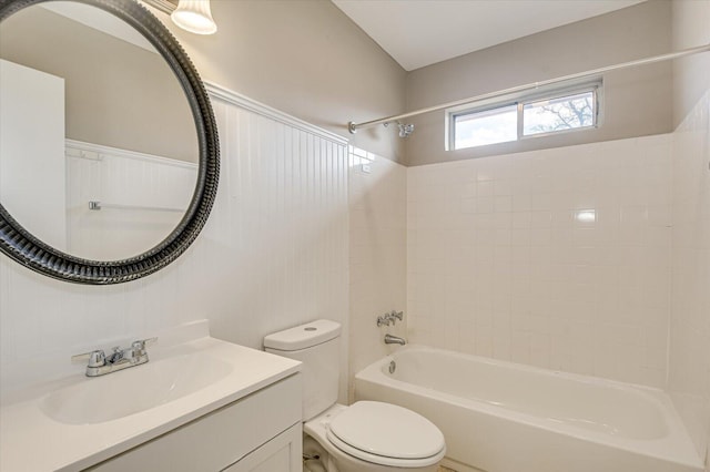 full bathroom featuring tiled shower / bath combo, vanity, and toilet