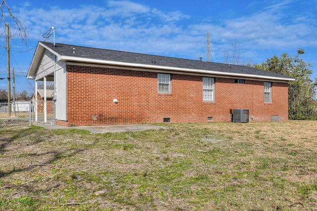 rear view of property with central AC unit, a yard, and a patio area