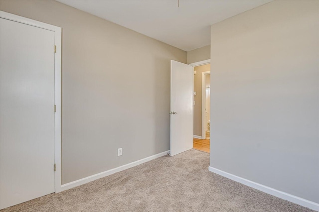 unfurnished room featuring light carpet