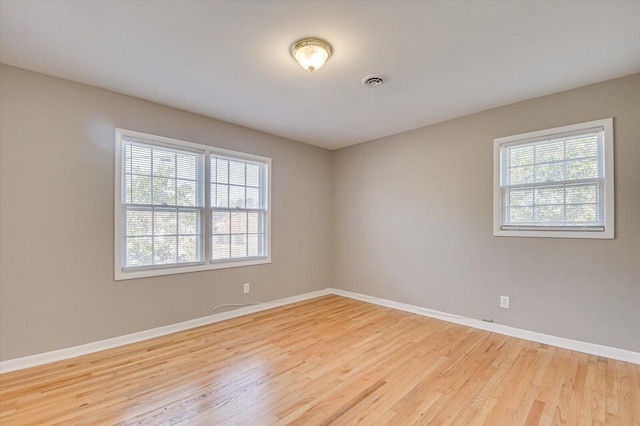 unfurnished room featuring plenty of natural light and light hardwood / wood-style floors