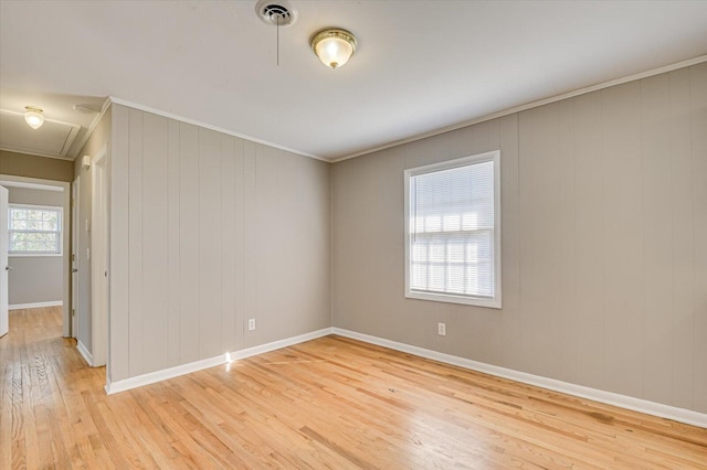 spare room featuring ornamental molding and light hardwood / wood-style floors