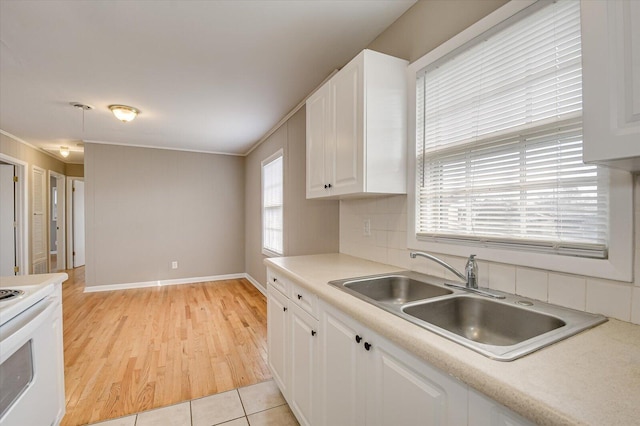 kitchen featuring sink, light tile patterned floors, tasteful backsplash, white cabinets, and white electric stove