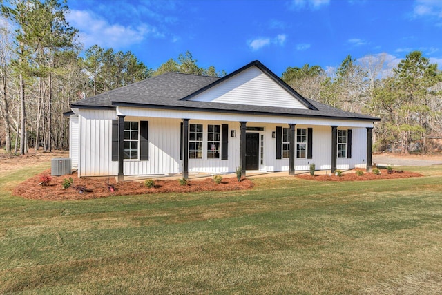 view of front of property featuring a front lawn, roof with shingles, a porch, and central air condition unit