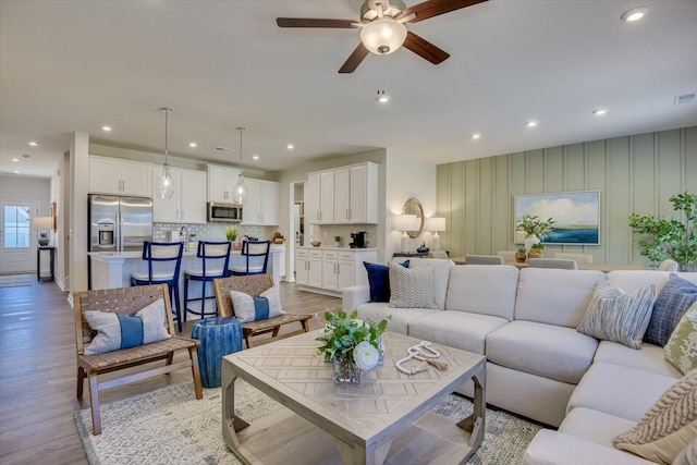 living room featuring ceiling fan, light wood-style flooring, and recessed lighting