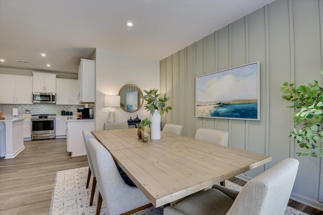 dining space featuring light wood-style flooring and recessed lighting