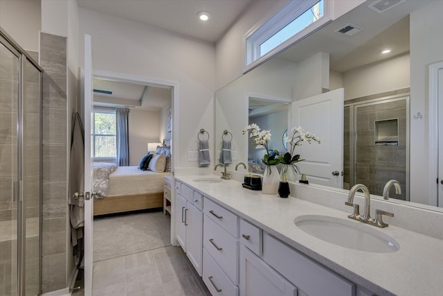 ensuite bathroom featuring a stall shower, visible vents, a sink, and double vanity