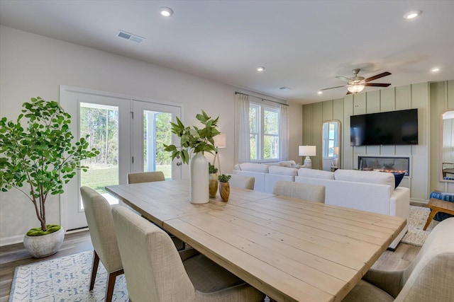 dining area with a large fireplace, wood finished floors, visible vents, and recessed lighting