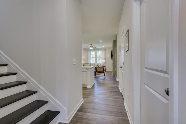 corridor featuring stairs, baseboards, and dark wood-style flooring