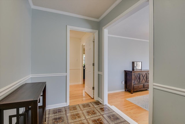 hallway featuring crown molding, baseboards, and wood finished floors