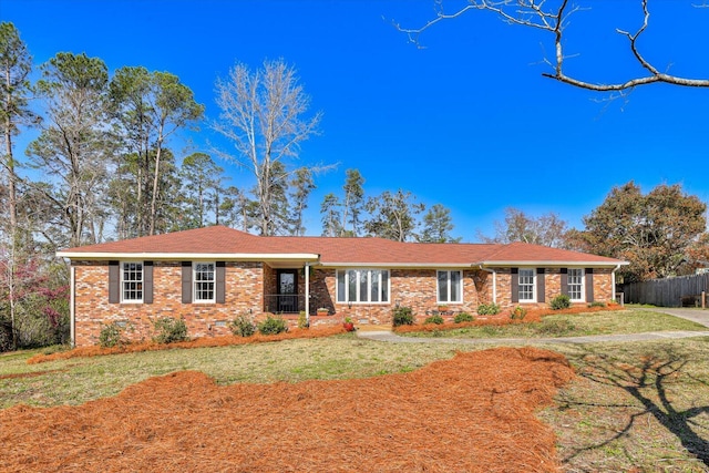 single story home with brick siding, a front yard, and fence