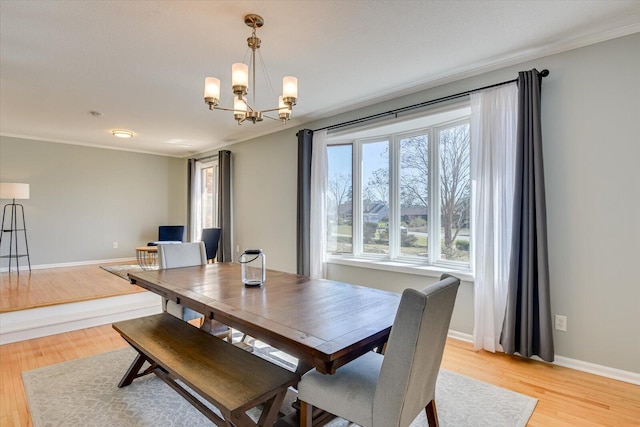 dining room featuring an inviting chandelier, ornamental molding, and light wood finished floors