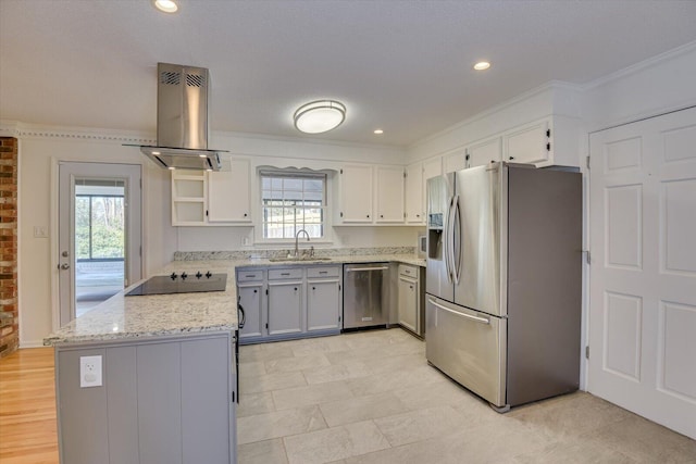 kitchen featuring ornamental molding, light stone counters, island exhaust hood, stainless steel appliances, and a sink