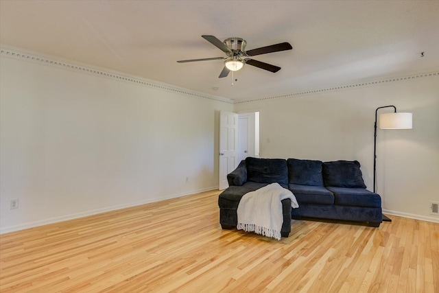 living room featuring baseboards, a ceiling fan, and wood finished floors