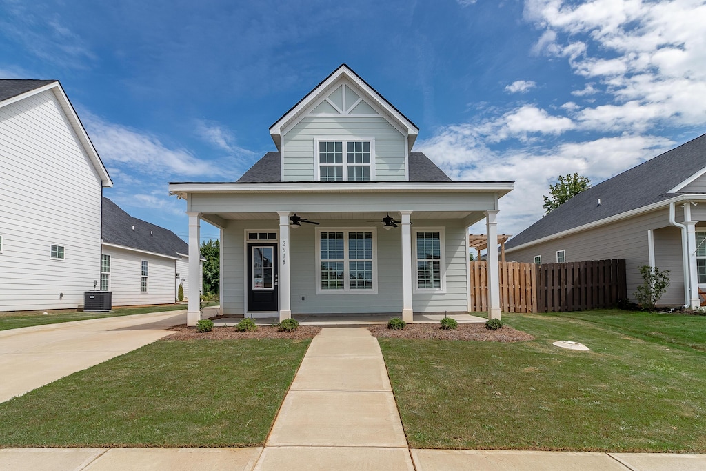 view of front of property with central AC, ceiling fan, a front lawn, and a porch