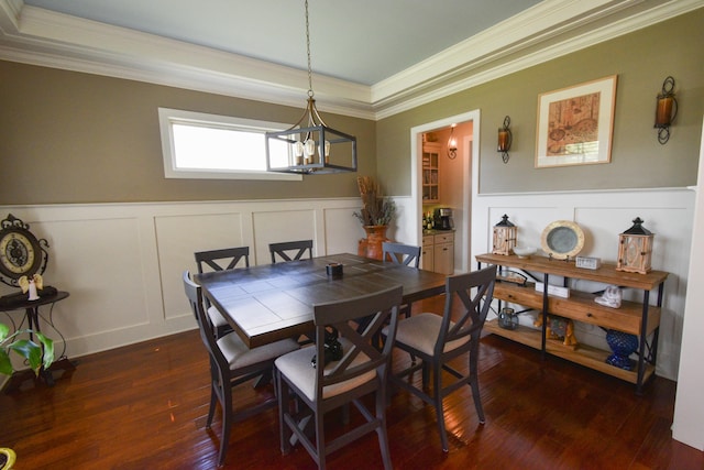 dining room with dark wood-type flooring, a notable chandelier, and ornamental molding