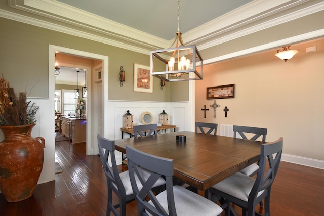 dining area featuring dark hardwood / wood-style flooring, an inviting chandelier, and ornamental molding