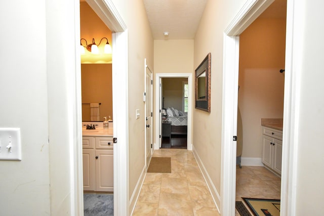 corridor with sink and light tile patterned flooring