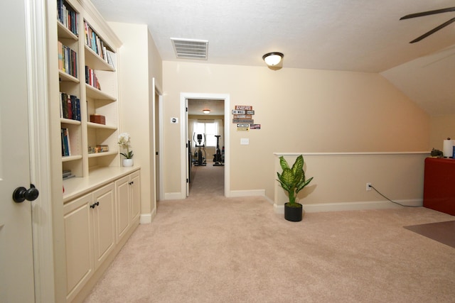 corridor featuring lofted ceiling and light carpet