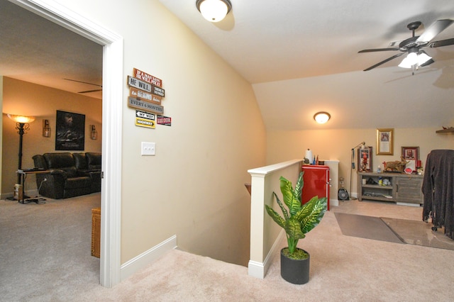 hallway featuring light carpet and vaulted ceiling