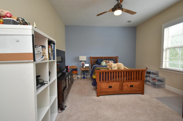 bedroom with multiple windows, ceiling fan, and light colored carpet