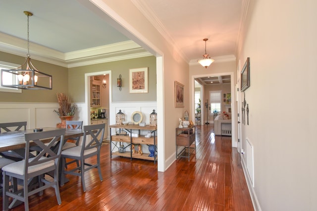 dining area featuring ornamental molding, dark hardwood / wood-style floors, and an inviting chandelier