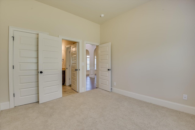 1037 Dietrich Ln, North Augusta, SC 29860 - unfurnished bedroom featuring light colored carpet, arched walkways, and baseboards