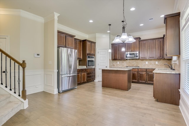 1037 Dietrich Ln, North Augusta, SC 29860 - kitchen with appliances with stainless steel finishes, a center island, a sink, decorative backsplash, and light wood-style flooring