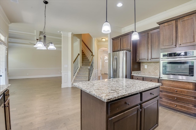 1037 Dietrich Ln, North Augusta, SC 29860 - kitchen with appliances with stainless steel finishes, arched walkways, crown molding, light wood finished floors, and light stone countertops
