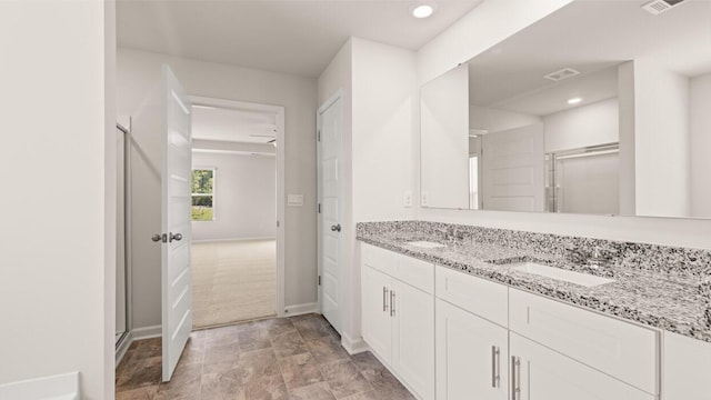 bathroom featuring baseboards, a stall shower, and a sink