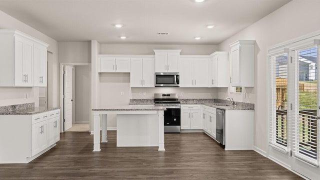 kitchen with dark wood-style flooring, appliances with stainless steel finishes, white cabinetry, and a sink