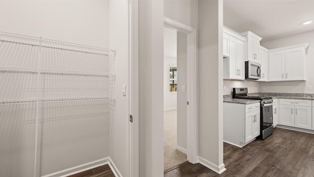 kitchen with white cabinetry, dark wood-style flooring, and appliances with stainless steel finishes