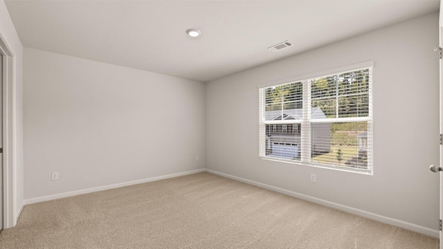 spare room featuring carpet flooring, visible vents, and baseboards