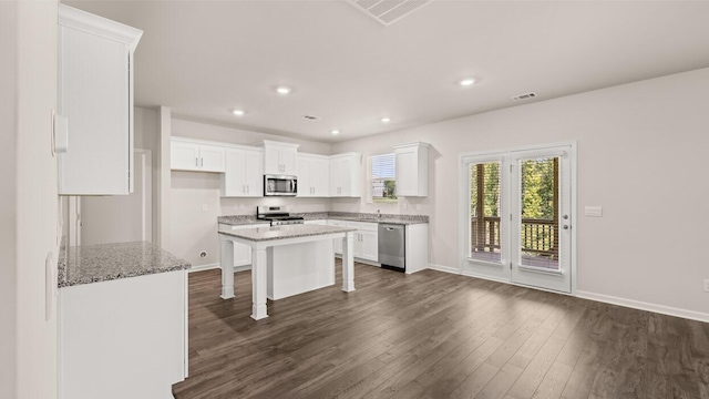 kitchen with a breakfast bar area, dark wood-style floors, visible vents, appliances with stainless steel finishes, and white cabinetry