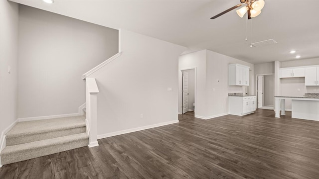 unfurnished living room featuring stairway, baseboards, a ceiling fan, and dark wood-style flooring