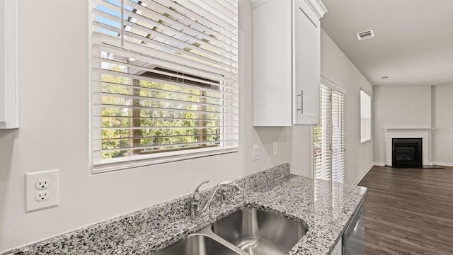 kitchen with visible vents, a sink, dark wood-style floors, open floor plan, and white cabinetry