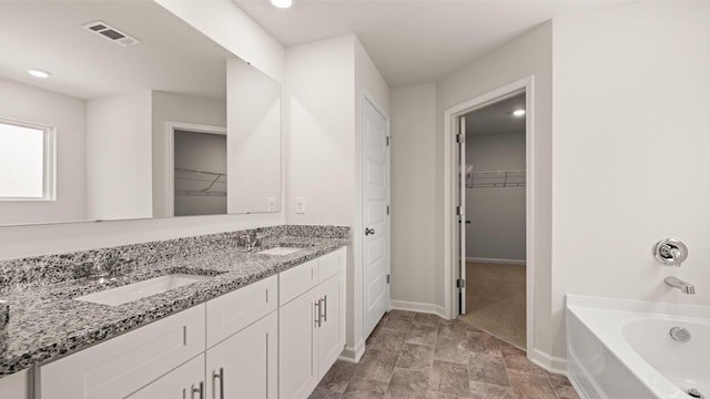 bathroom featuring a sink, visible vents, baseboards, and a bath