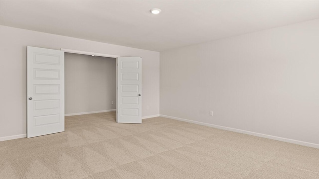 unfurnished bedroom with light colored carpet and baseboards