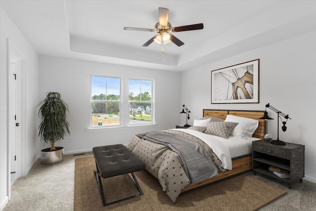 bedroom featuring carpet flooring, ceiling fan, and a tray ceiling