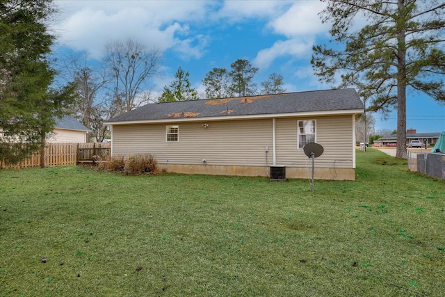 rear view of house featuring a yard and fence