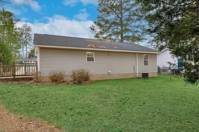 rear view of property with a deck, a lawn, and cooling unit