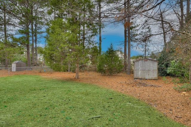 view of yard featuring a shed, fence, and an outdoor structure